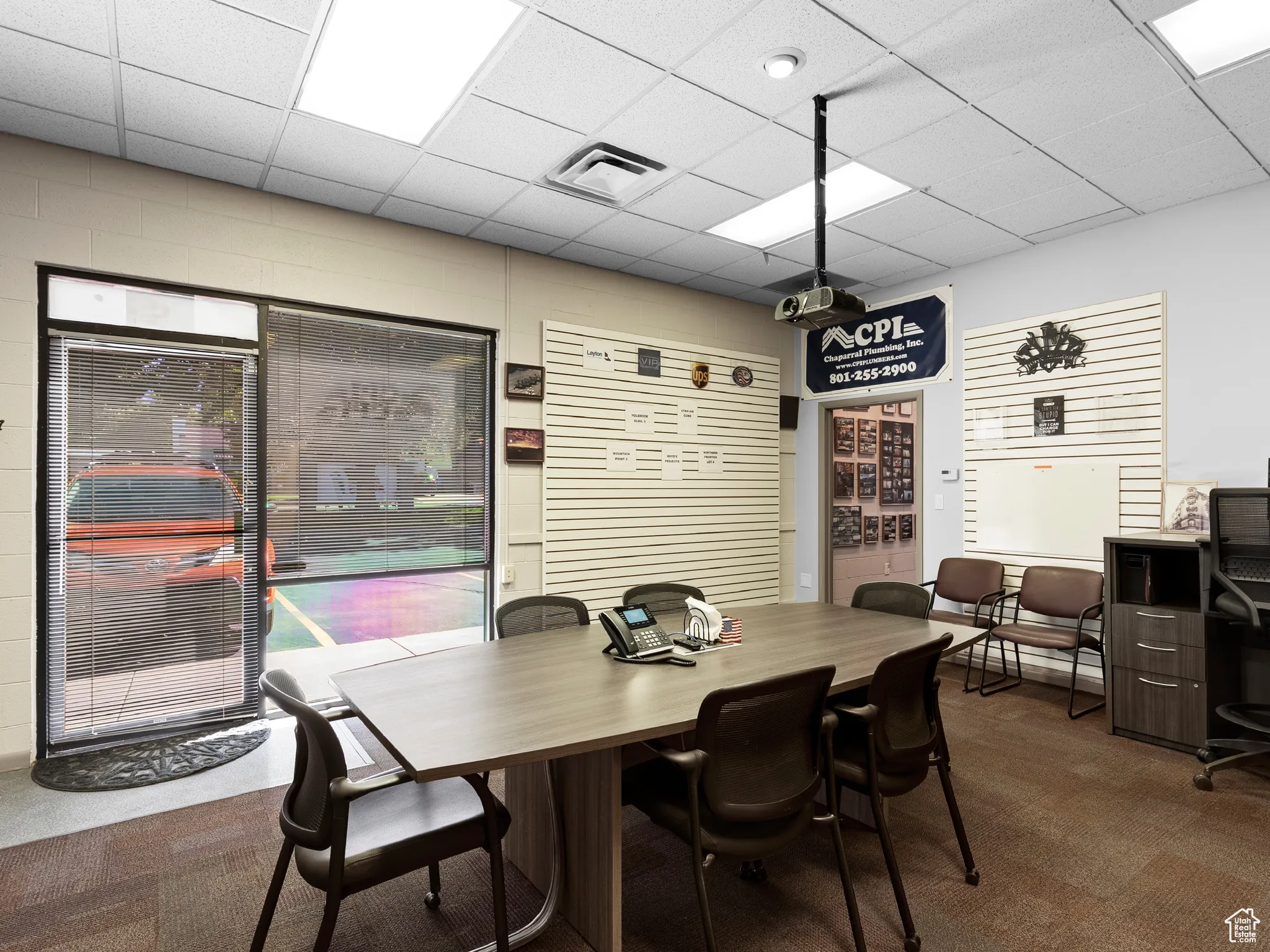 Dining room featuring dark colored carpet and a drop ceiling
