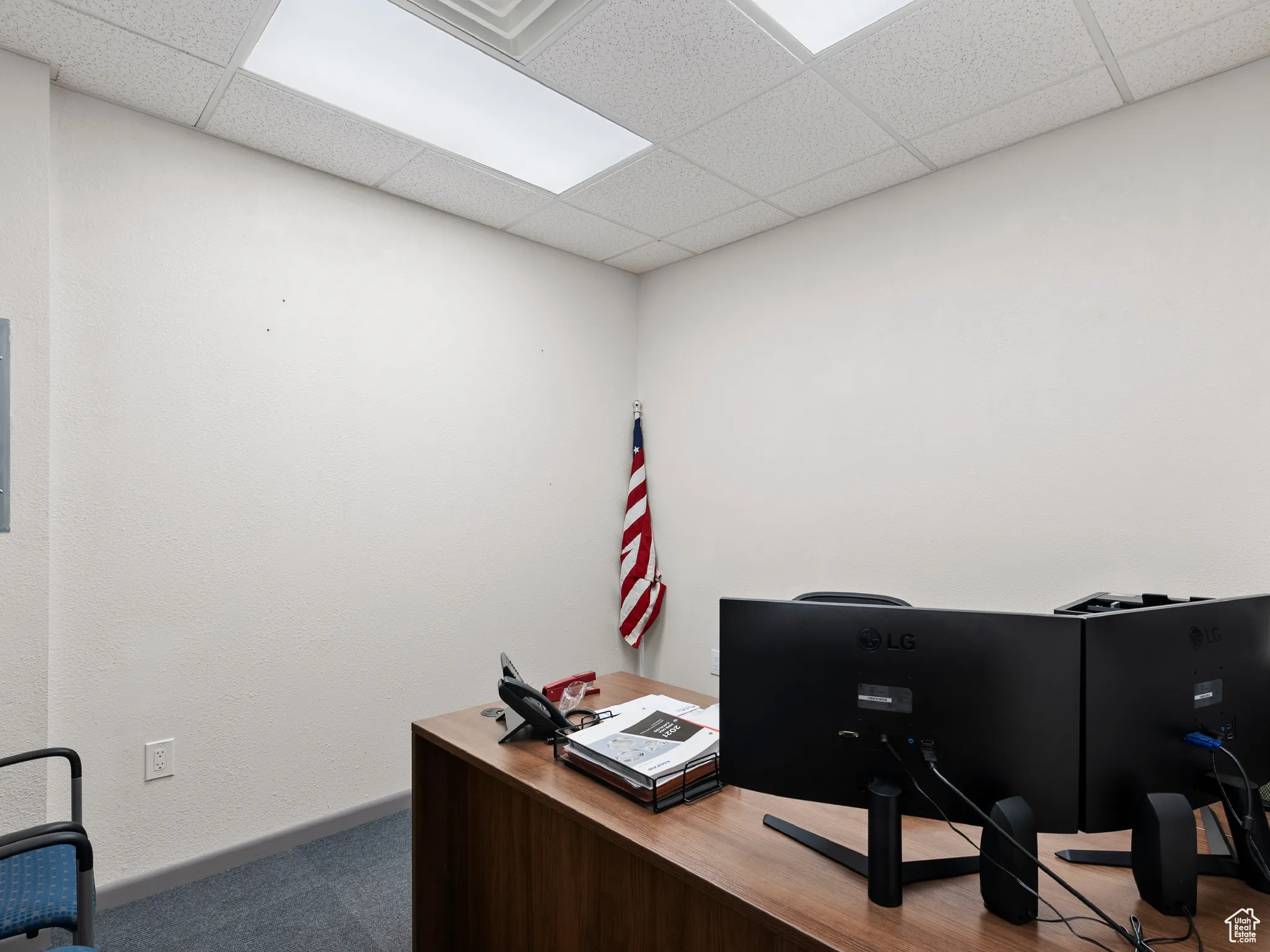 Office with a paneled ceiling and carpet
