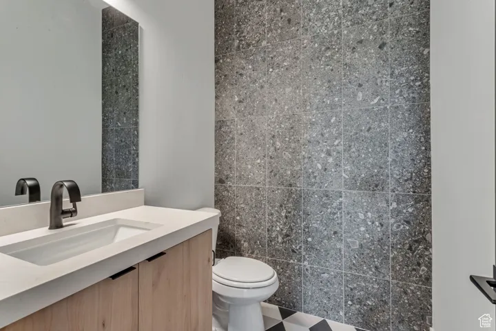 Guest Bathroom featuring vanity and tile walls