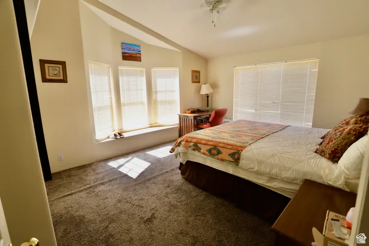 Bedroom featuring lofted ceiling, carpet, and ceiling fan