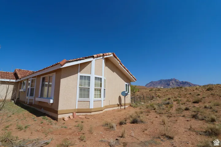 View of home's exterior with stucco siding, a tiled roof, and a mountain view