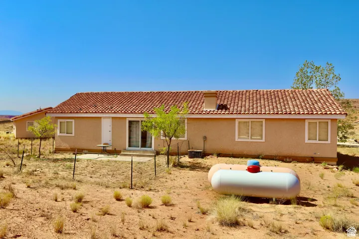 Back of property with a tile roof and stucco siding