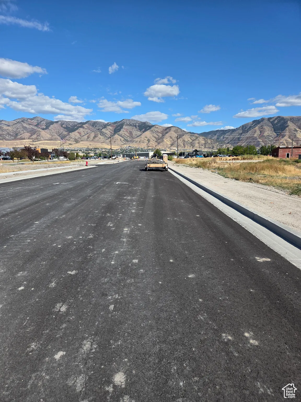 View of asphalt street featuring a mountain view and curbs