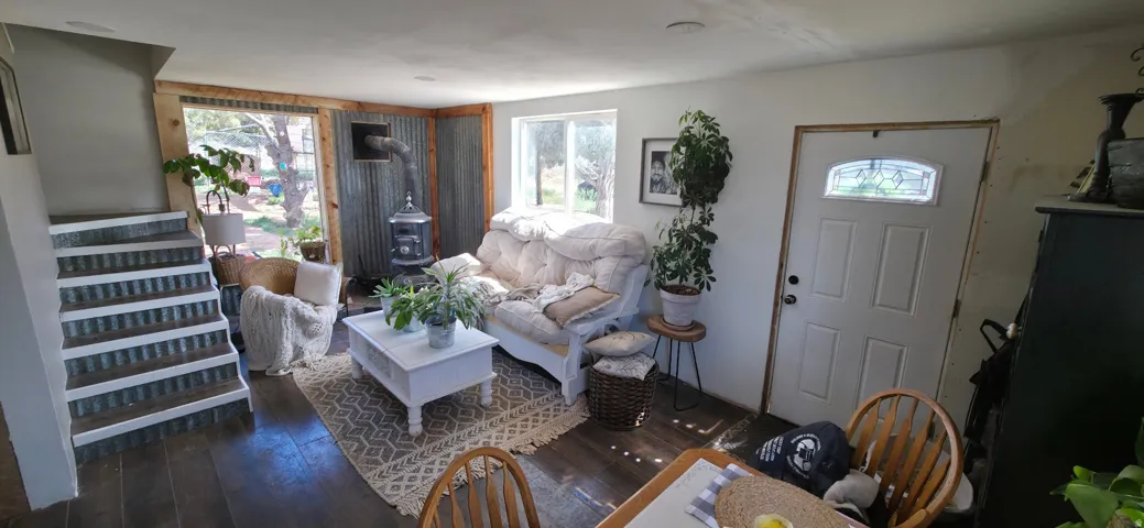 Living room with dark wood finished floors and healthy amount of natural light