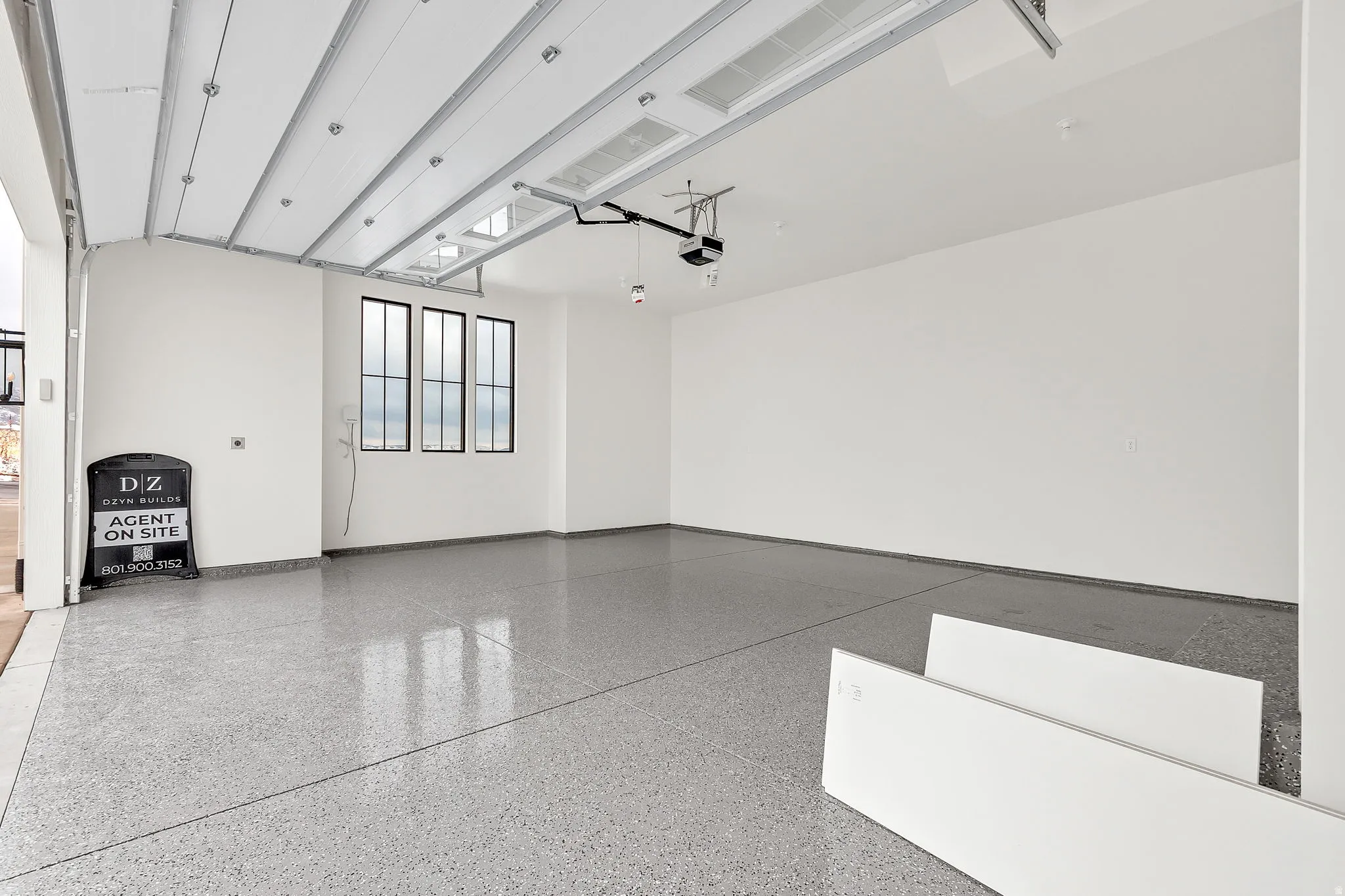 Main level 2 car garage with epoxied flooring and EV charging