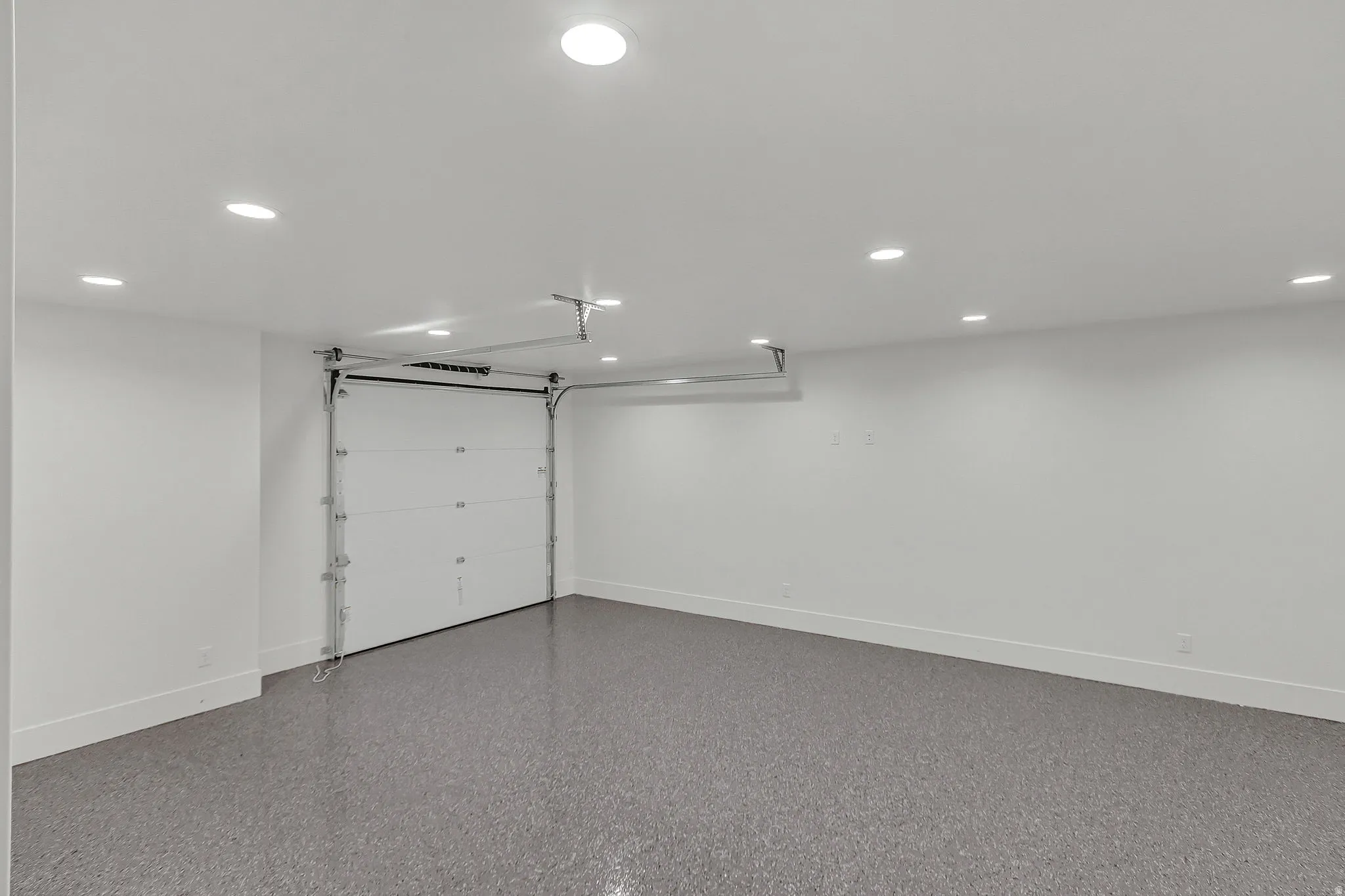 Downstairs gym featuring an epoxied floor and a garage door