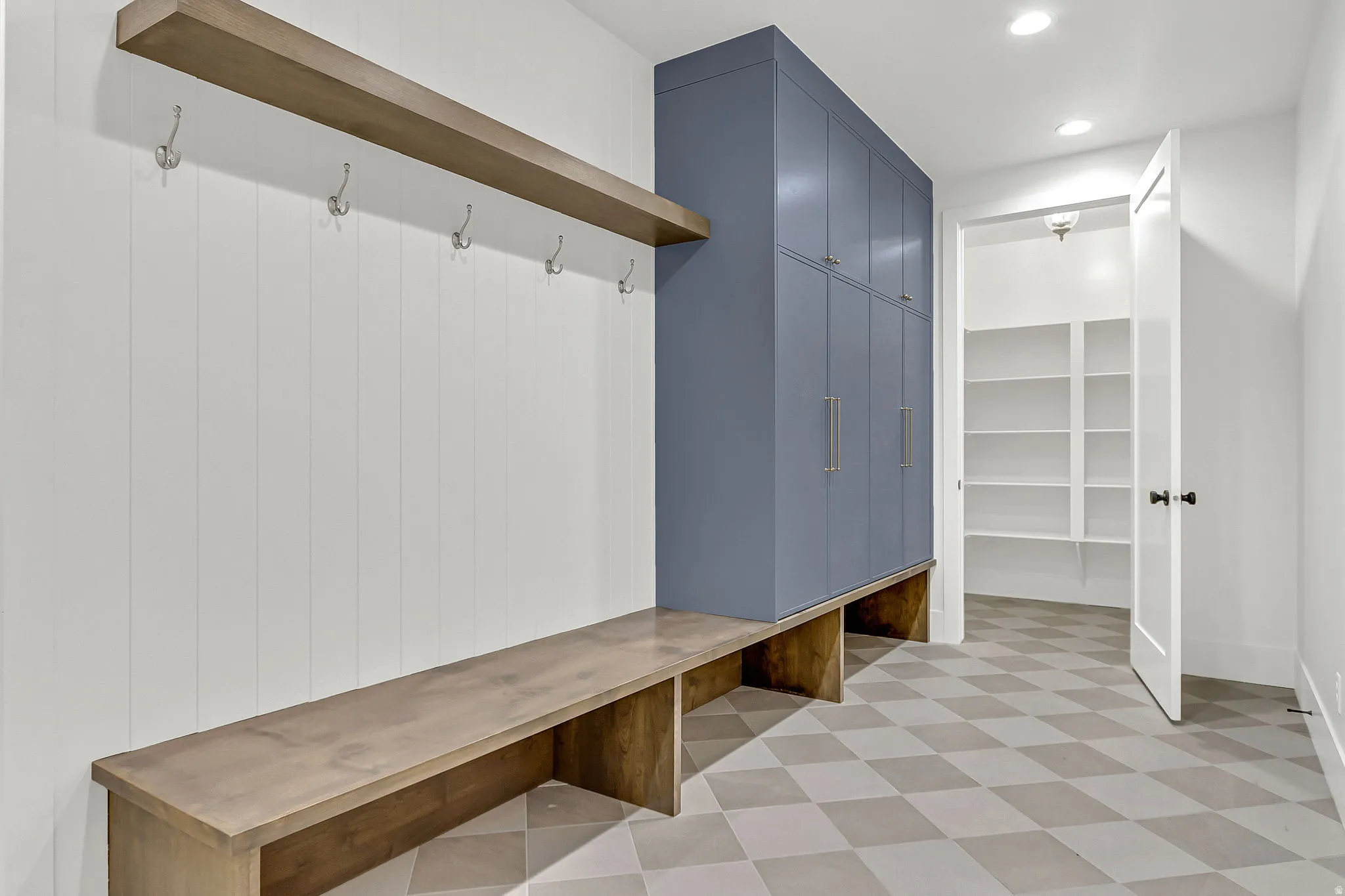 Main level mudroom off the garage with storage lockers and a huge closet with built in shelving