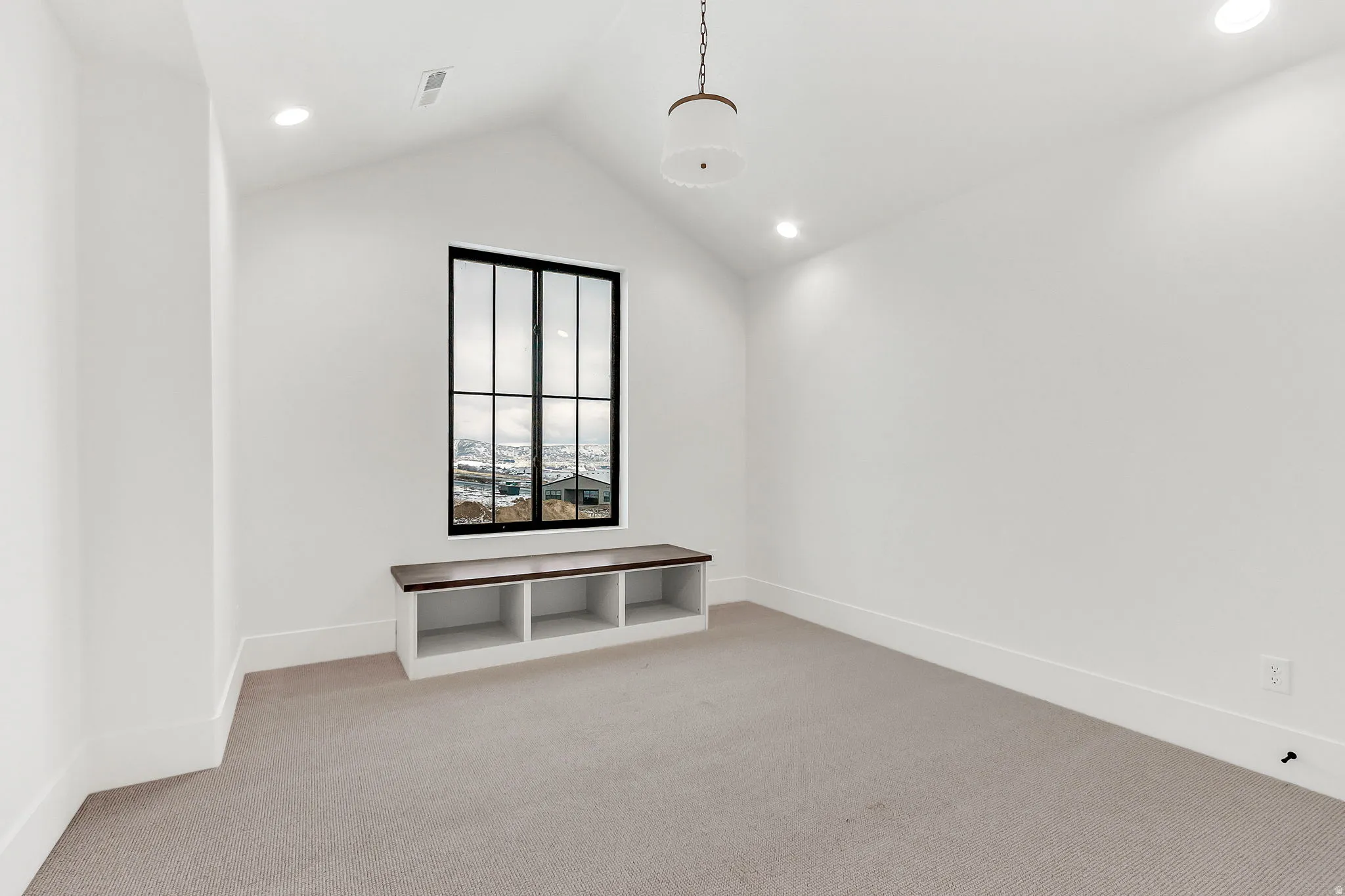 Upstairs bedroom 1 with a vaulted ceiling and built in bench
