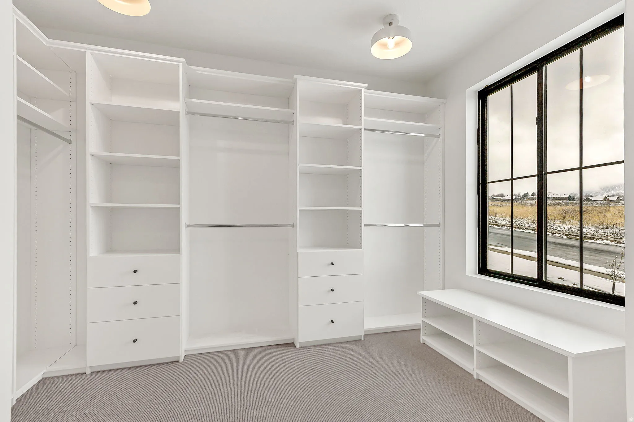 Primary closet featuring built in storage and dressing bench