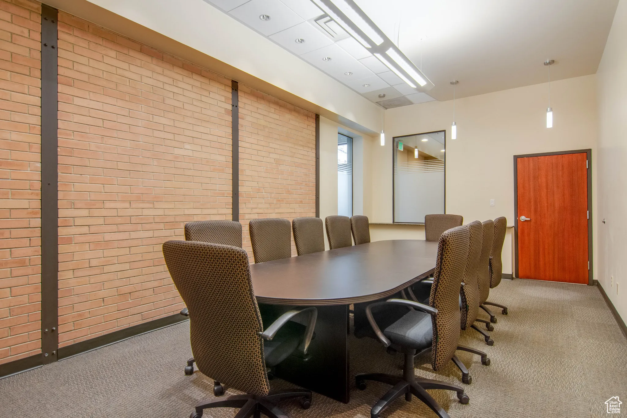 Office area with brick wall and light carpet