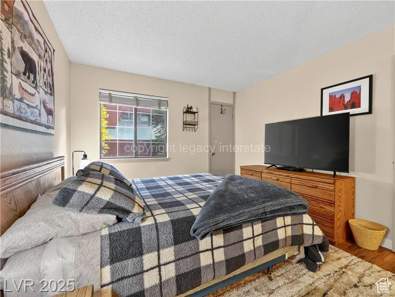 Bedroom featuring wood finished floors and a textured ceiling