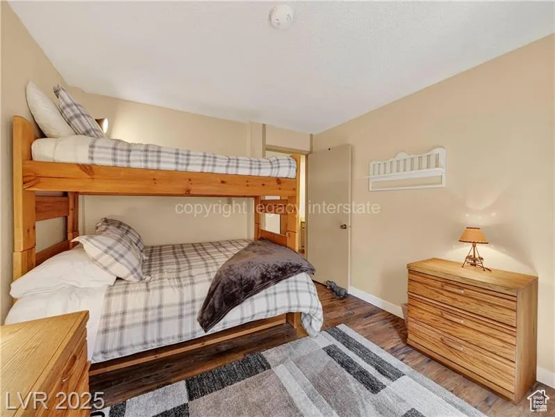 Bedroom featuring wood finished floors and baseboards