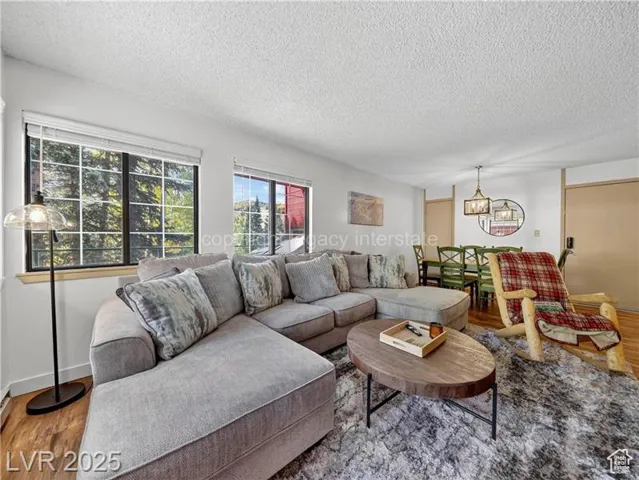 Living area featuring wood finished floors, a textured ceiling, and a chandelier