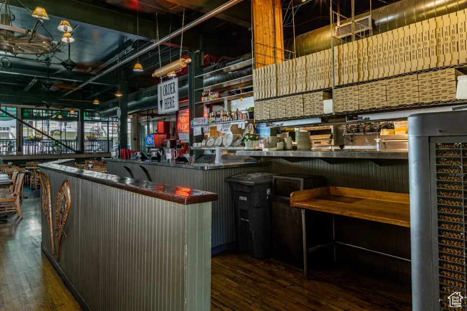 Community bar area featuring dark countertops, dark wood-type flooring, and open shelves