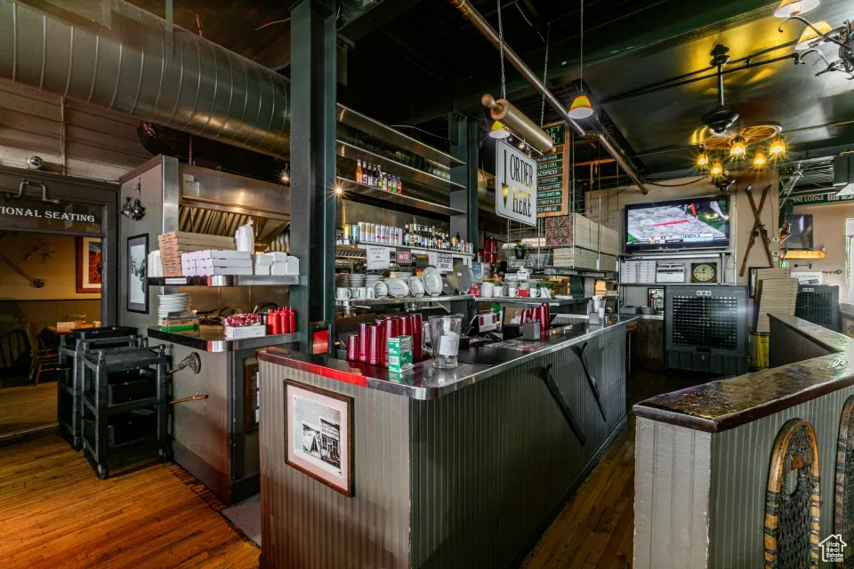 Kitchen featuring open shelves, dark wood-type flooring, and stainless steel countertops