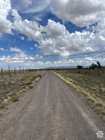 View of dirt / gravel road featuring a view of rural / pastoral area