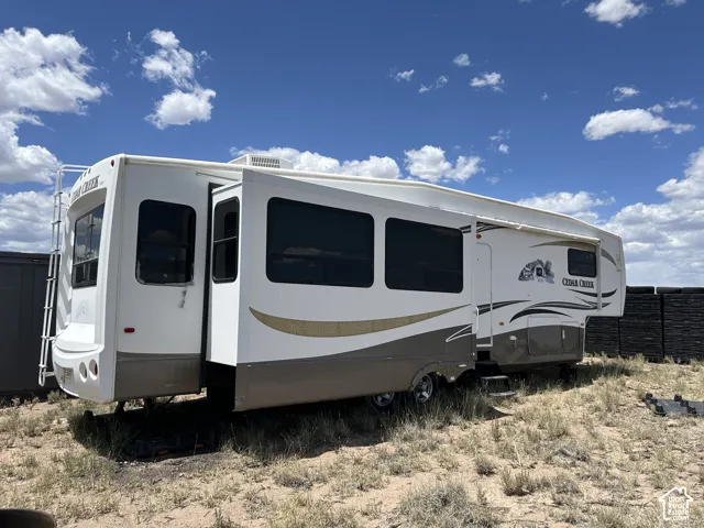 Fifth-wheel recreational vehicle with a white and tan exterior