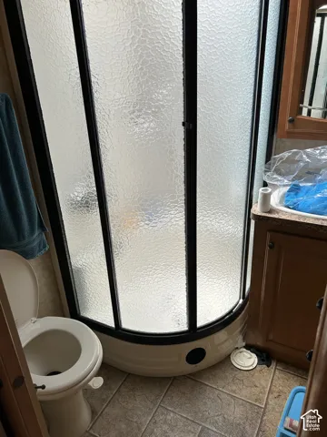 Curved shower enclosure with textured glass panels, black framing, and a white base
