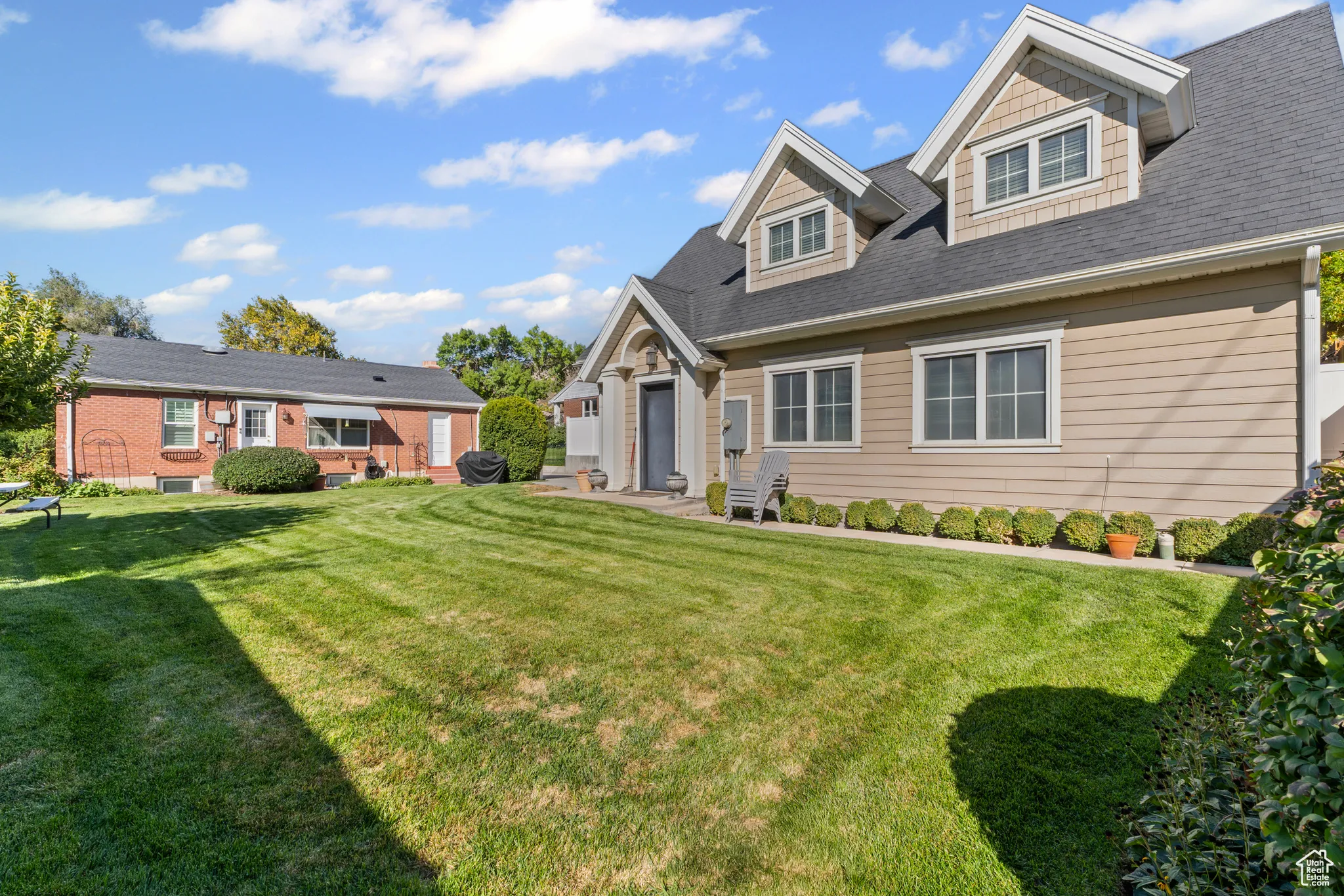 Cape cod home with a front lawn and roof with shingles