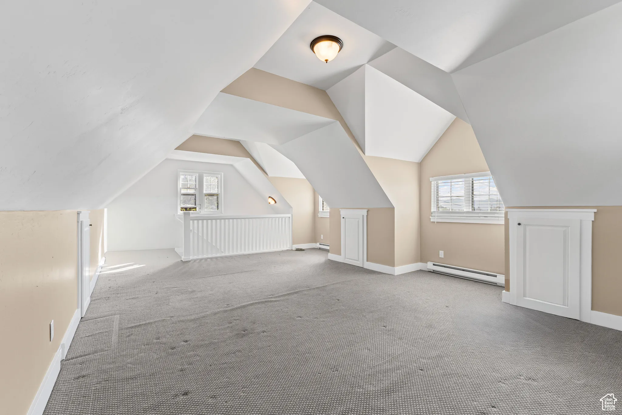 Bonus room featuring lofted ceiling, a baseboard heating unit, and carpet