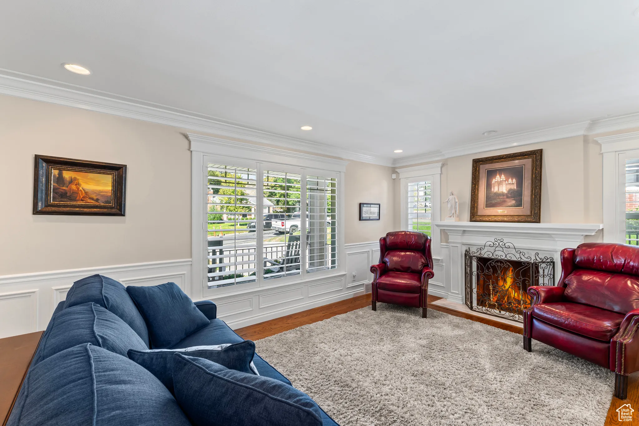 Living area featuring plenty of natural light, a high end fireplace, ornamental molding, recessed lighting, and wood finished floors