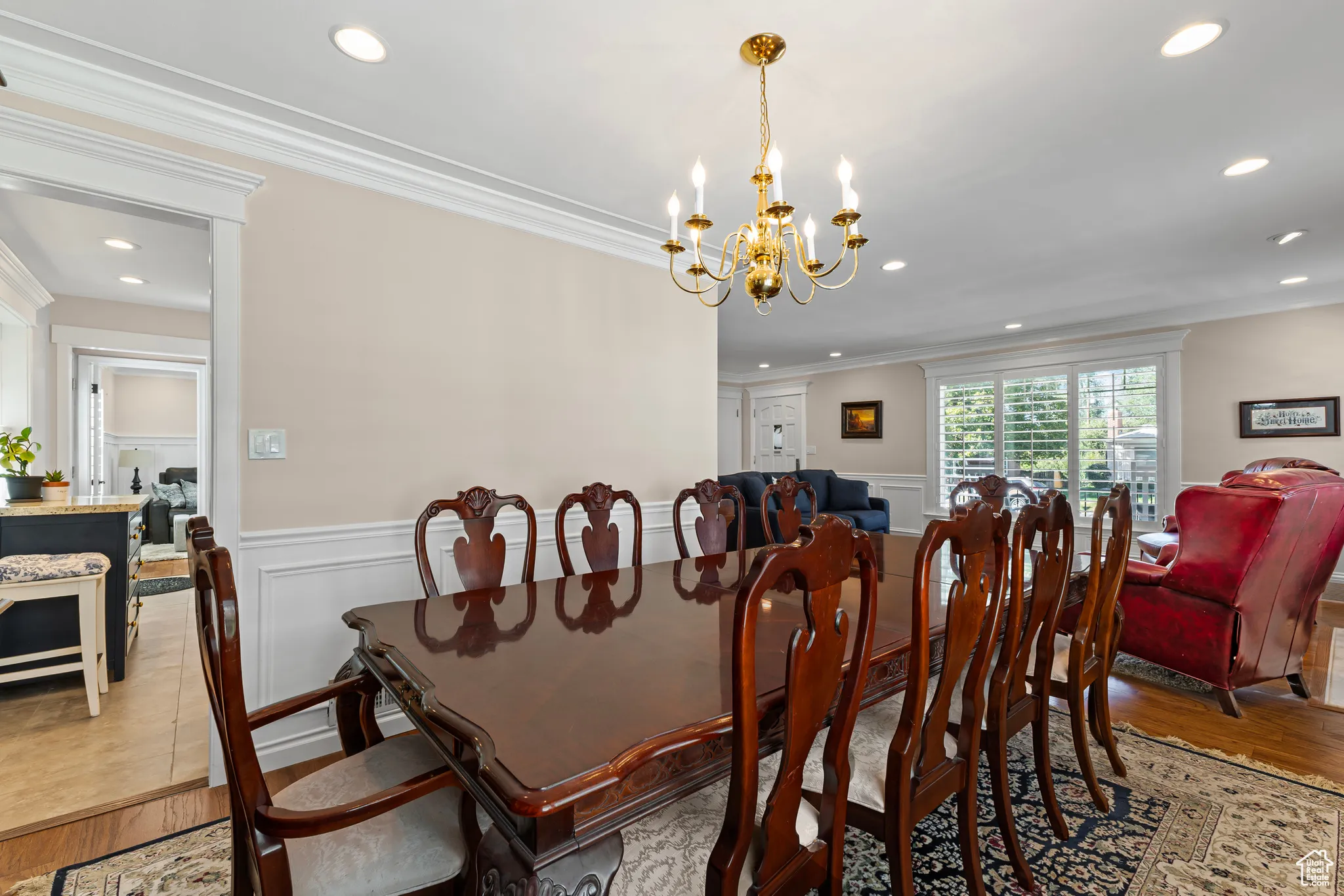 Dining space with wood finished floors, crown molding, recessed lighting, a chandelier, and wainscoting