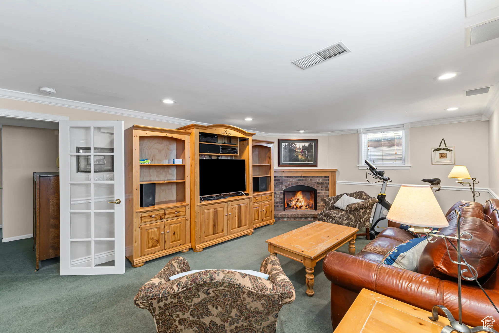 Living area with crown molding, a fireplace, carpet flooring, and recessed lighting