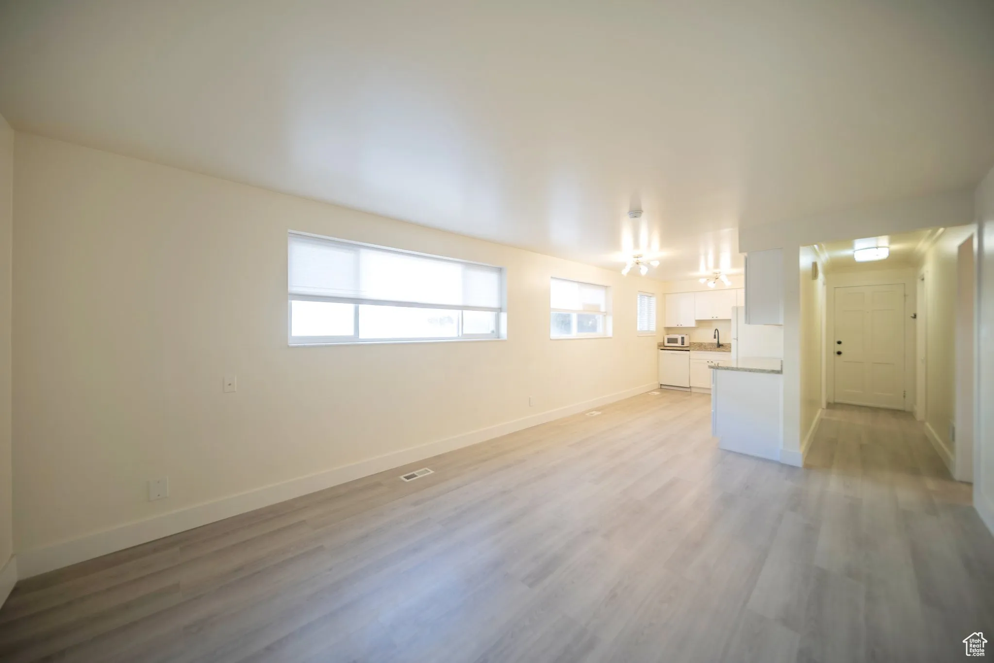 Unfurnished living room featuring healthy amount of natural light and light wood finished floors