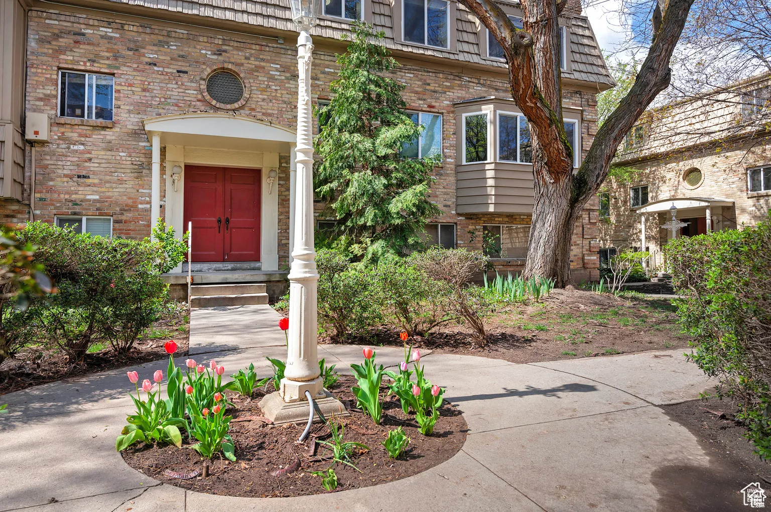 View of exterior entry featuring mansard roof and brick siding