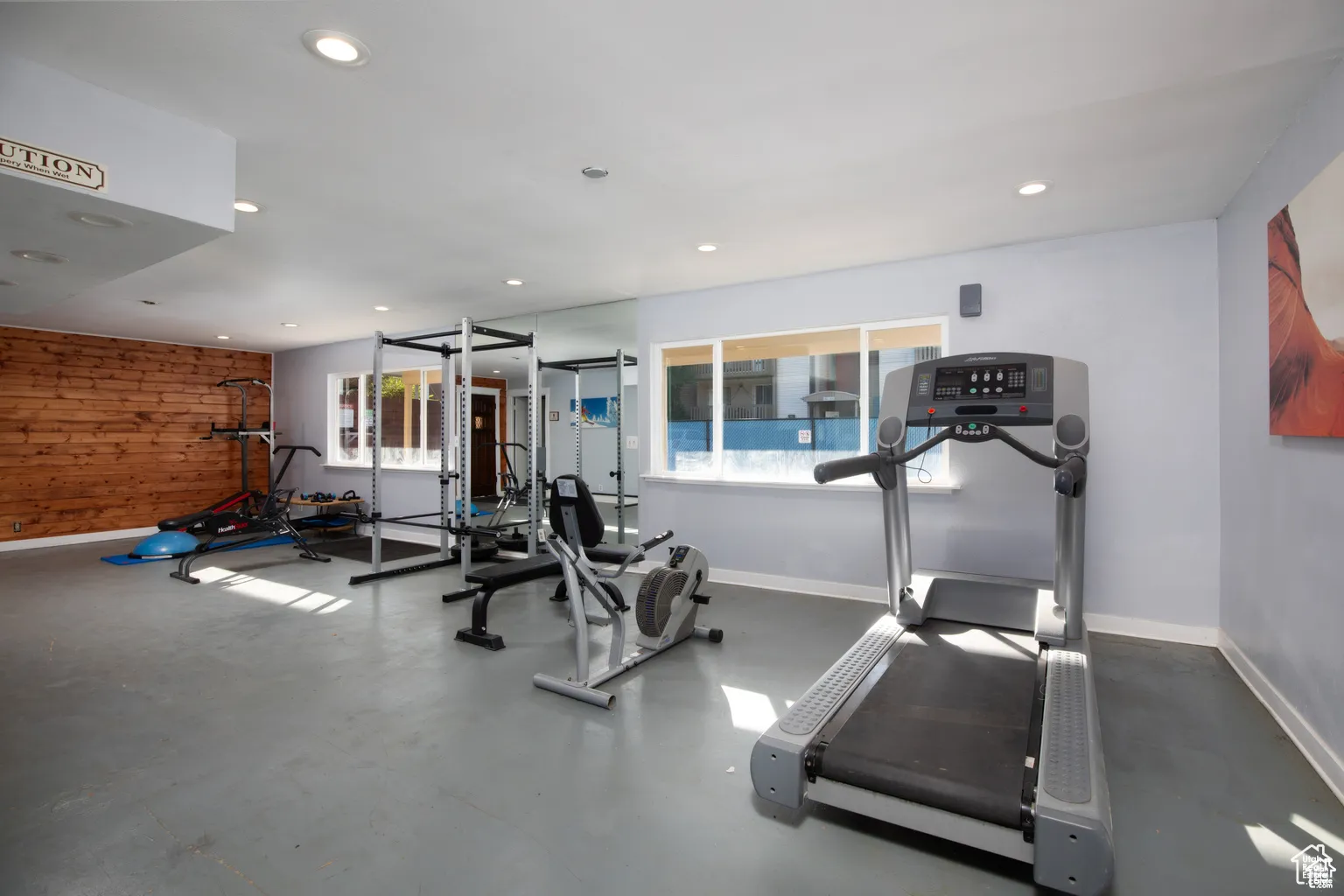 Exercise room with wooden walls and recessed lighting
