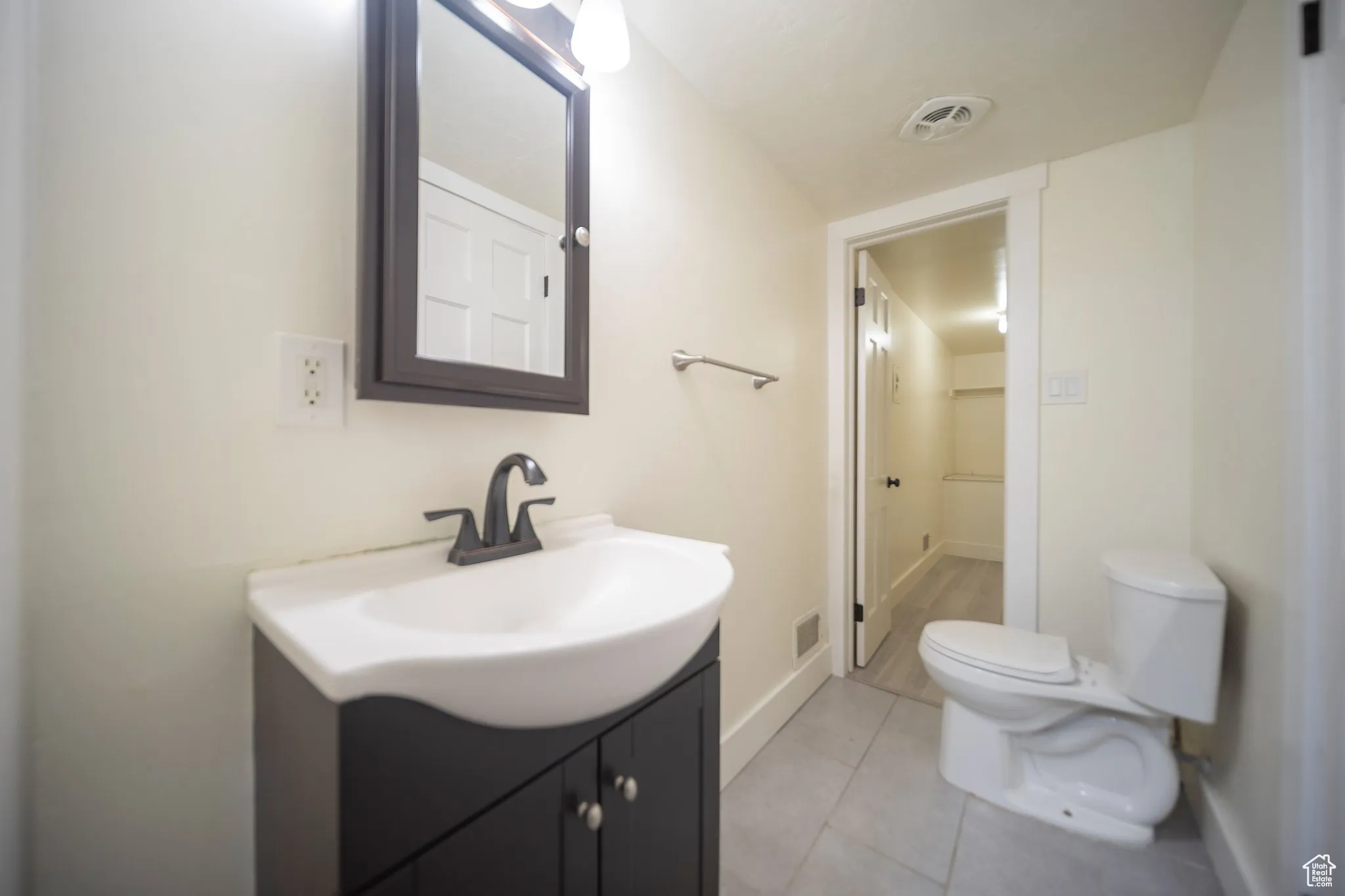 Half bath featuring vanity and light tile patterned floors