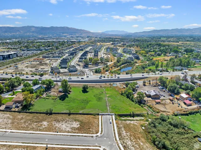 Aerial view of property and surrounding area featuring a mountainous background