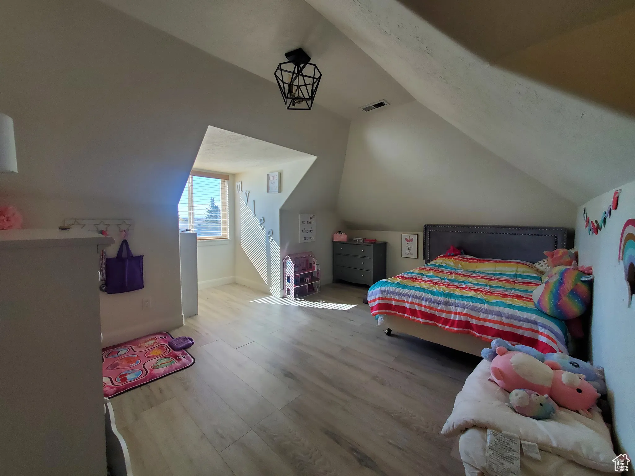 Bedroom #2upstairs with wood finished floors and vaulted ceiling