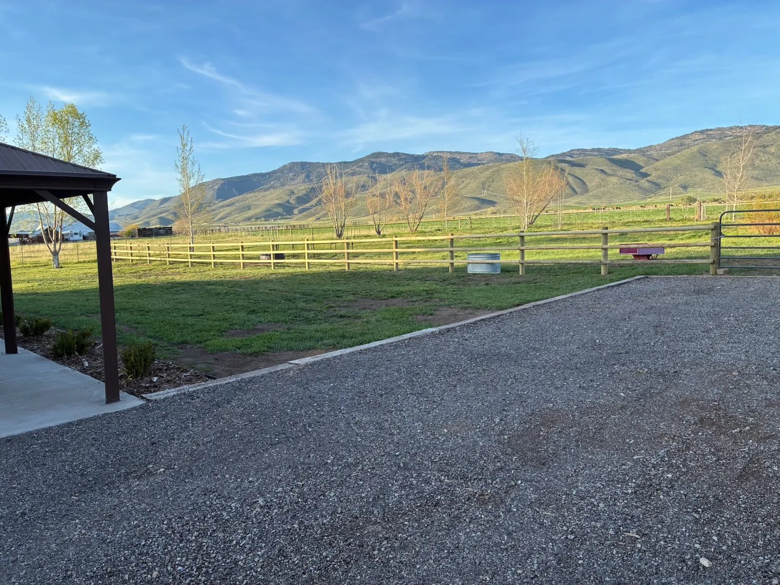 Expansive gravel driveway with a covered patio structure