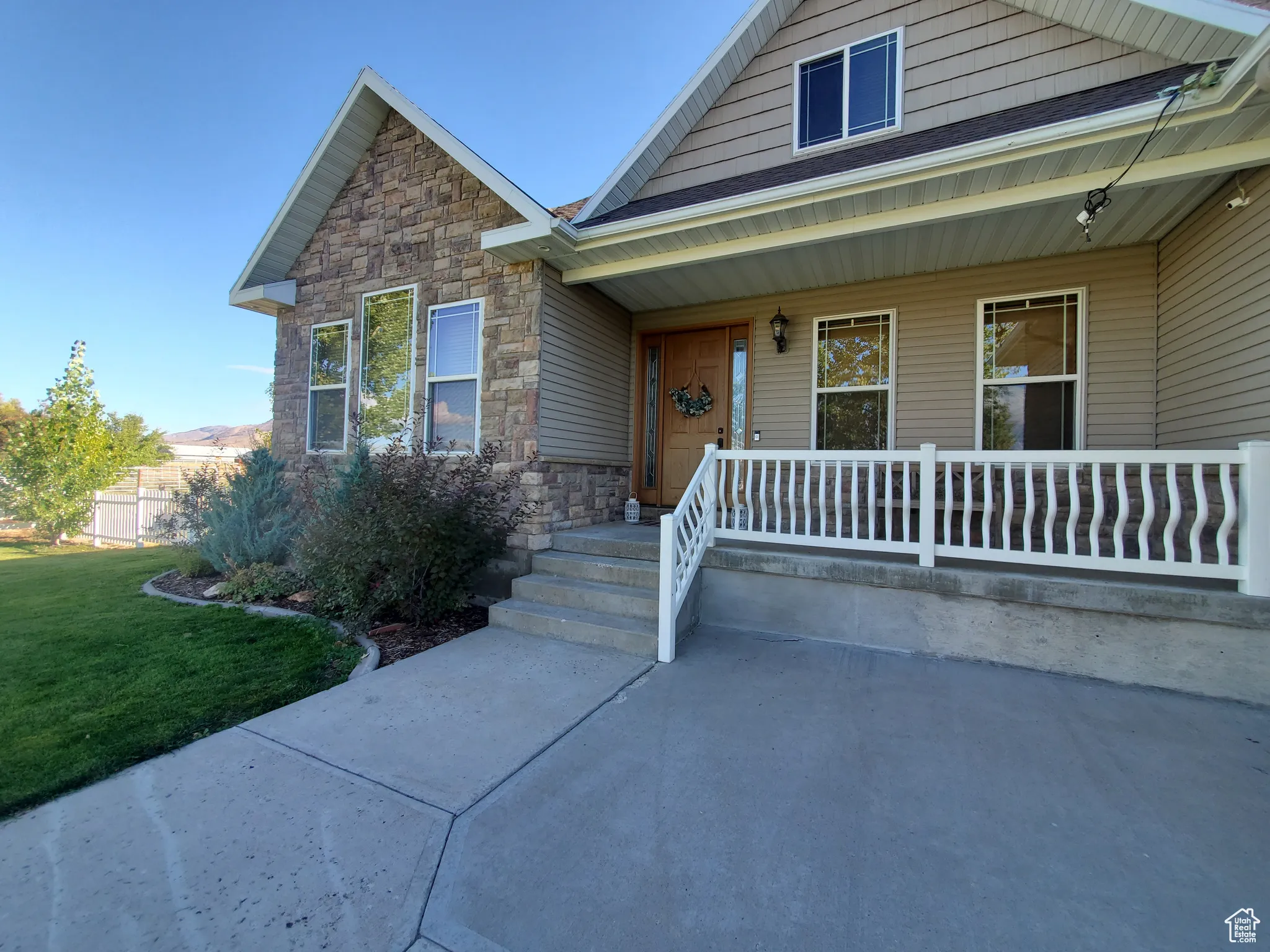 View of front facade with stone siding and covered porch