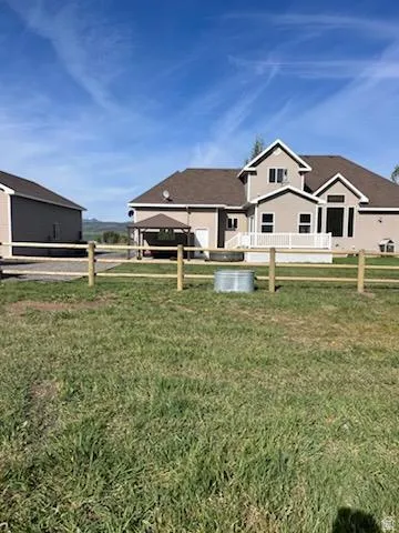 Expansive grassy yard with wood split rail fencing