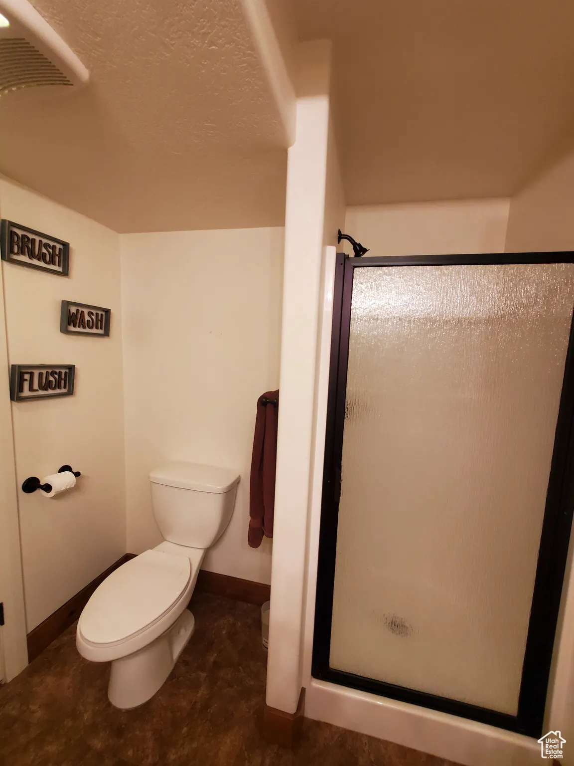 Bathroom in basement featuring a stall shower and a textured ceiling