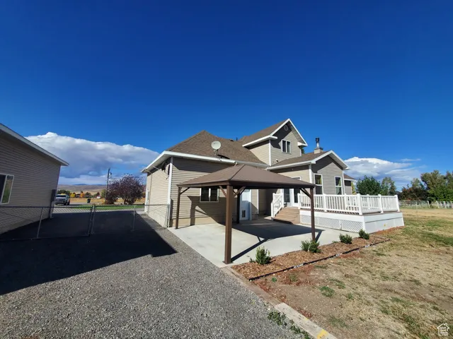 View of side of home featuring a patio area, a gazebo, and a gate