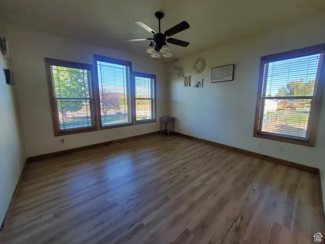 Master Bedroom on main floor. Unfurnished room with plenty of natural light, dark wood-style floors, and a ceiling fan