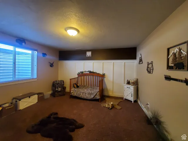 Bedroom #1 in basement featuring a textured ceiling and dark carpet