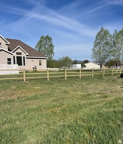 Expansive grassy yard area with split rail fencing