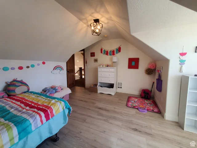 Bedroom #2 upstairs featuring wood finished floors and vaulted ceiling