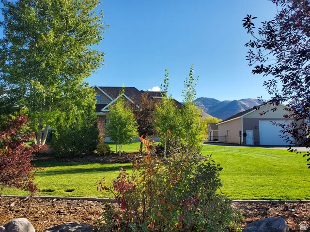 View of green lawn featuring a mountain view