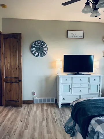 Master Bedroom with light wood finished floors and ceiling fan