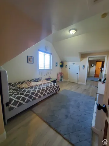Bedroom #3 upstairs with wood finished floors and lofted ceiling