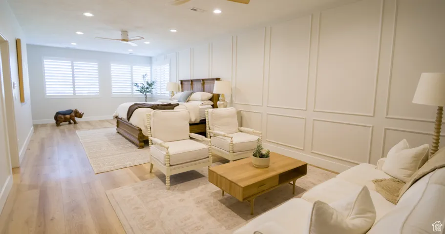 Bedroom featuring a decorative wall, light wood-style floors, recessed lighting, and ceiling fan