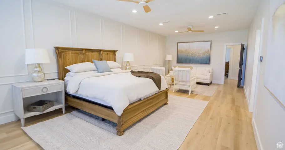 Bedroom with a decorative wall, recessed lighting, light wood-style floors, and ceiling fan