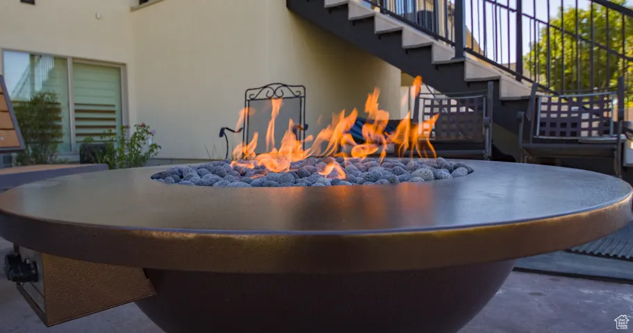 Exterior view of stucco siding, a fire pit, and stairway