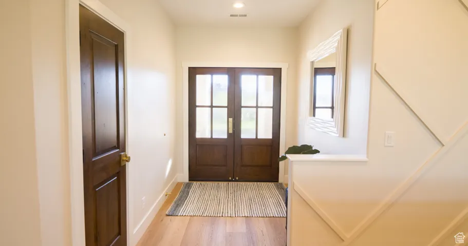 Doorway with wood finished floors and french doors