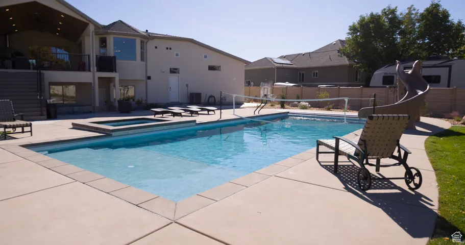 View of swimming pool with a patio, a balcony, a pool with connected hot tub, and a residential view